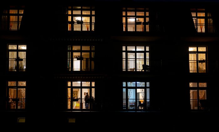 Illuminated windows of night house with people inside