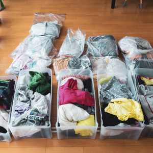 Woman organizes clothes in living room of her home