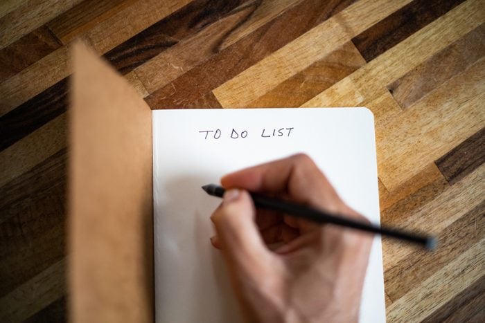 A person writing a to do list on a notebook