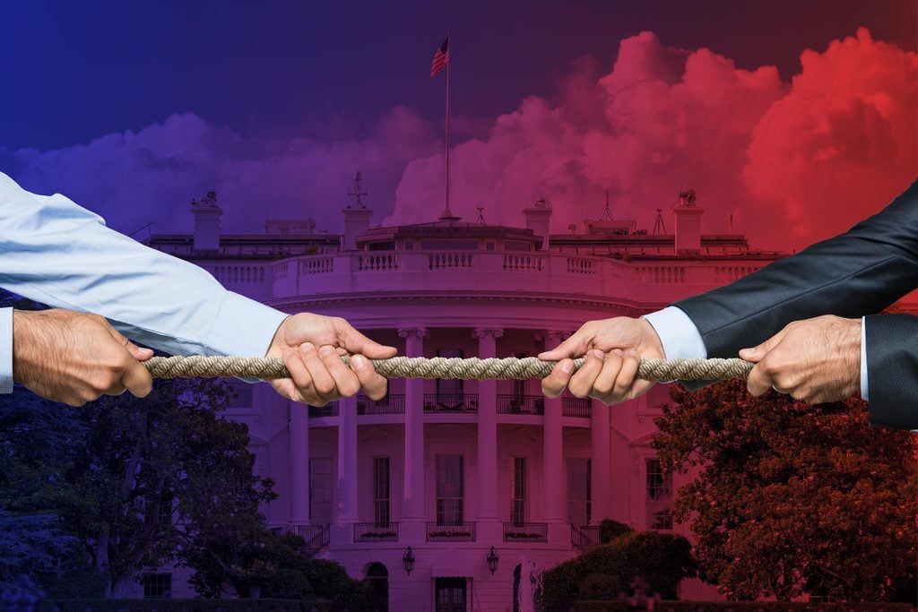 two businessmen pulling on a rope, tug-o-war style. White House background with red-to-blue fade overlay.