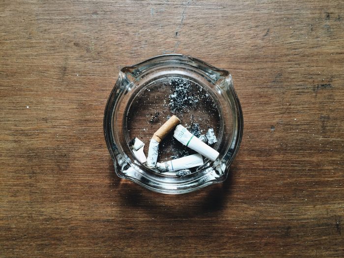 Directly Above Shot Of Cigarette Buts In Ashtray On Table