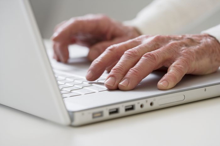 Close up of senior Hispanic man typing on computer