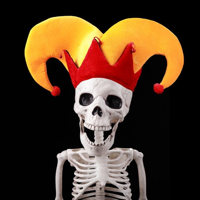 skeleton wearing a jokers hat on a black background