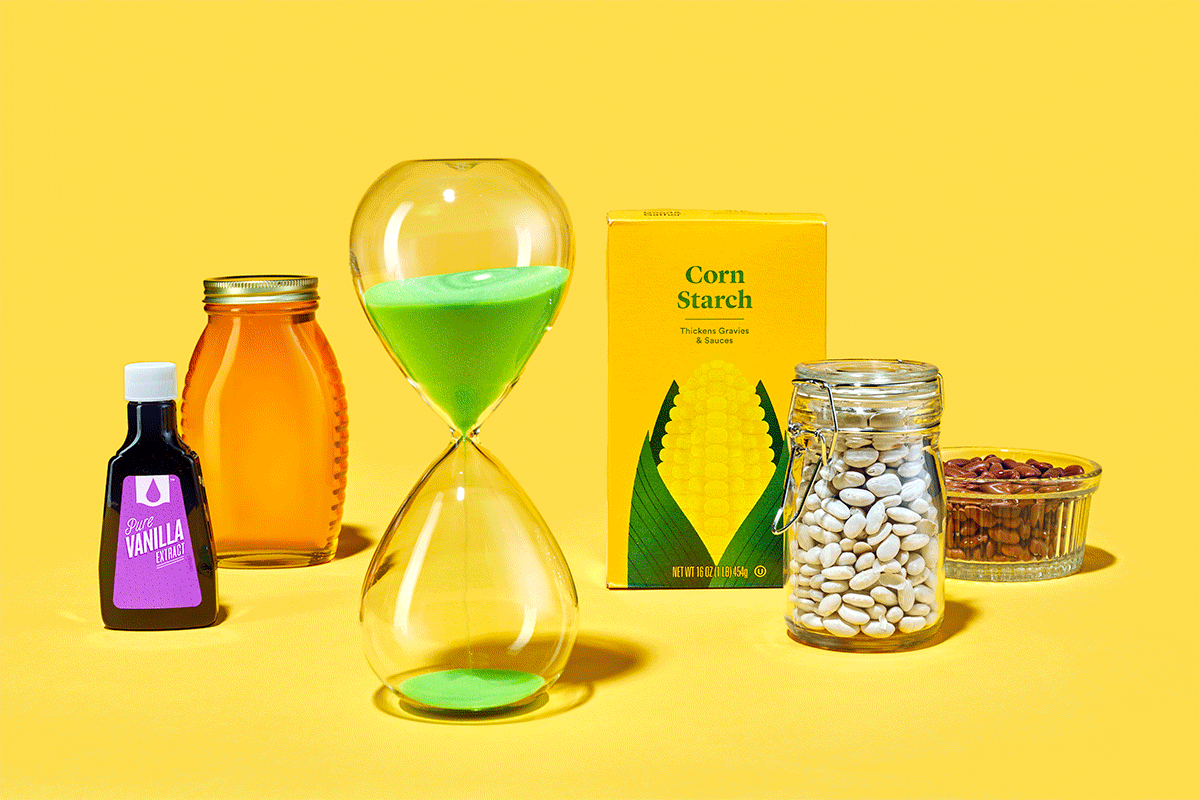 Sand passing through hourglass among pantry items