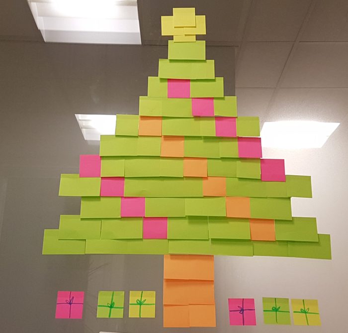 Adhesive Notes In Christmas Tree Shape On Glass Window
