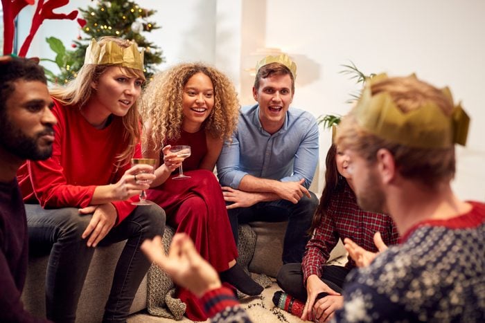 Group Of Friends Playing Charades After Enjoying Christmas Dinner At Home
