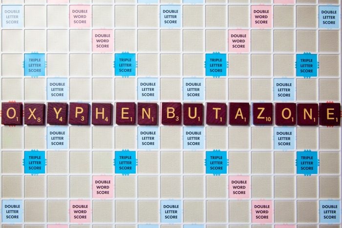 scrabble board with tiles that spell out oxyphenbutazone