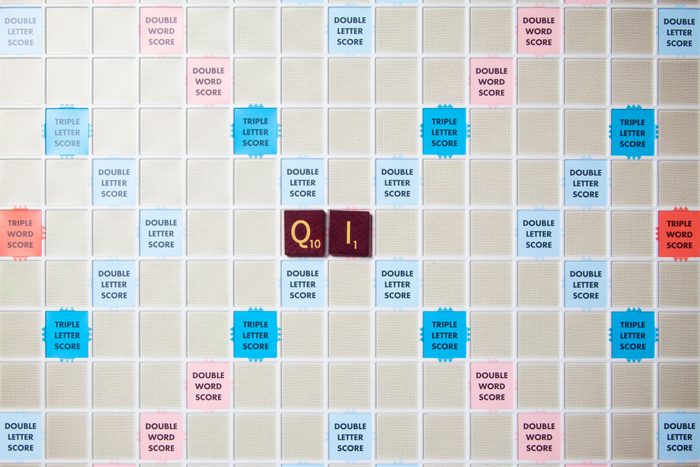 scrabble board with tiles that spell out qi