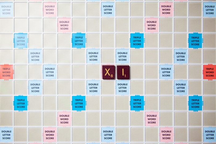 scrabble board with tiles that spell out xi