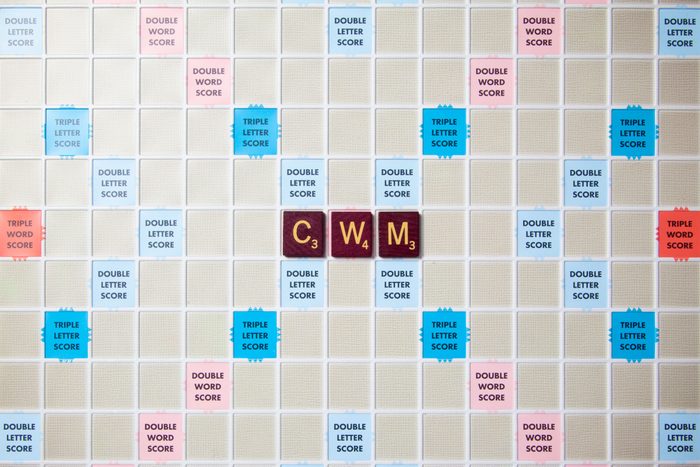 scrabble board with tiles that spell out cwm
