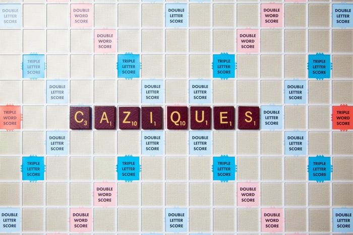 scrabble board with tiles that spell out caziques