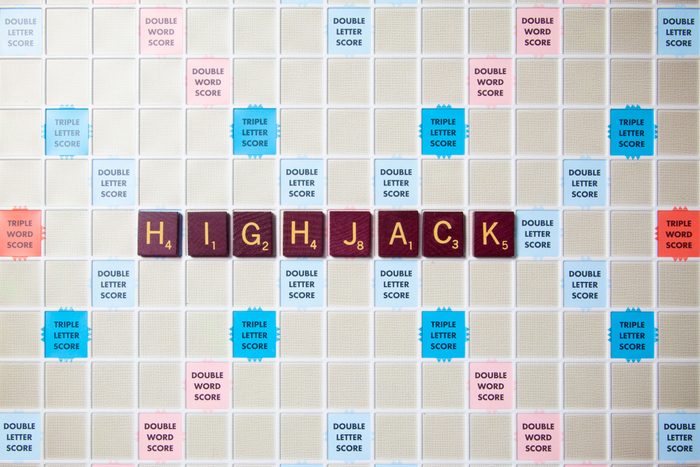 scrabble board with tiles that spell out highjack