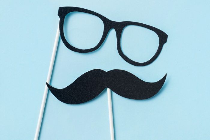 glasses and mustache photo booth props on blue background
