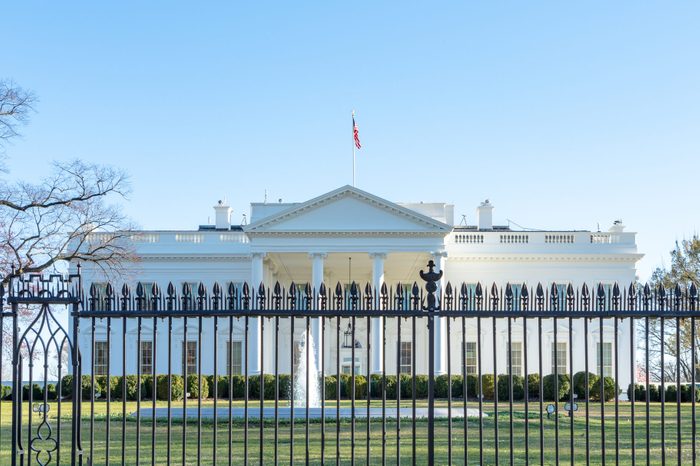 View of the white house in washington d.c. from afar, obstructed by the fence