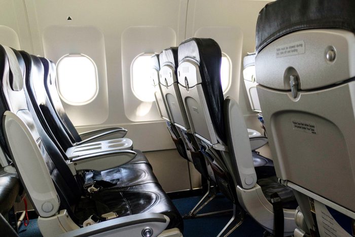 row of seats on an airplane with a black triangle above the window