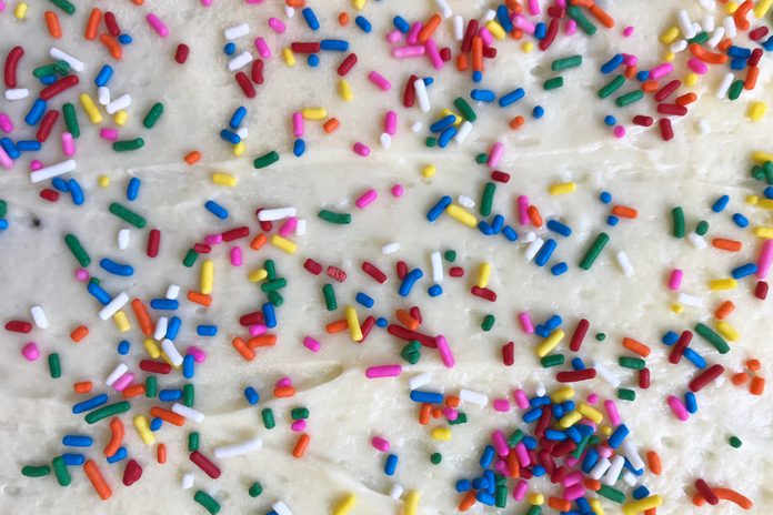 Close up of Rainbow Sprinkles or Jimmies or Sugar Strands on a Large Sheet Cake