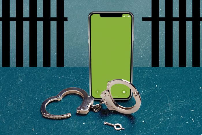 jailbroken iphone standing over unlocked handcuffs with broken jail bars in the background