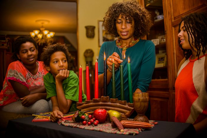 Family lighting kinara candles, celebrating Kwanzaa