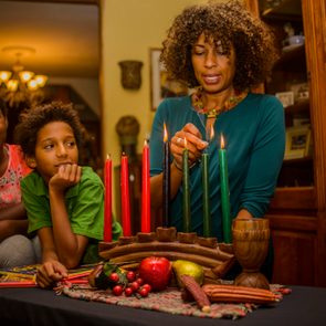 Family lighting kinara candles, celebrating Kwanzaa