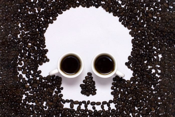 coffee beans shaped into a skull image with two coffee cups for eyes