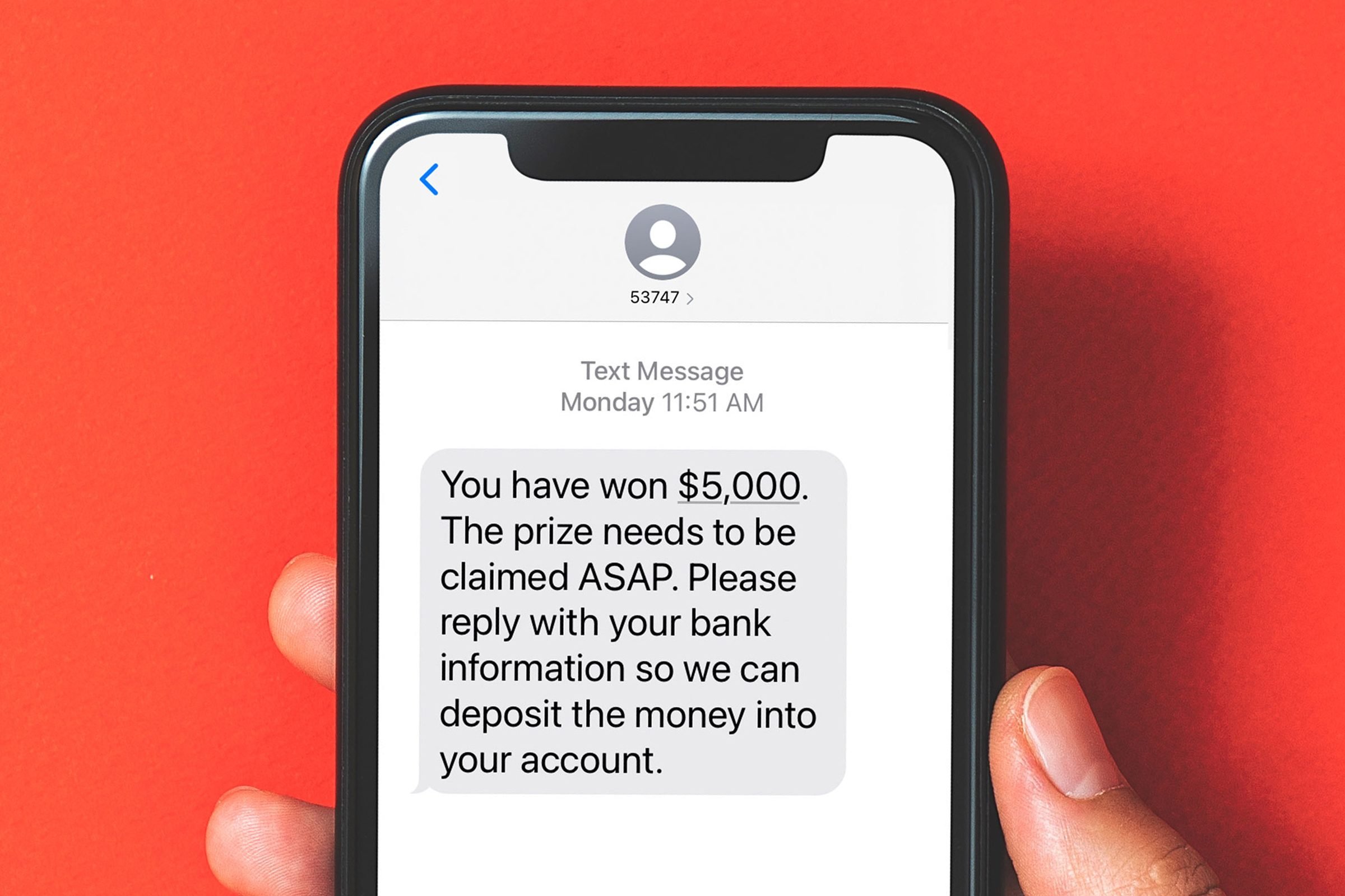Phone screen with a text from an unknown number: * "You have won $5,000. The prize needs to be claimed ASAP. Please reply with your bank information so we can deposit the money into your account."