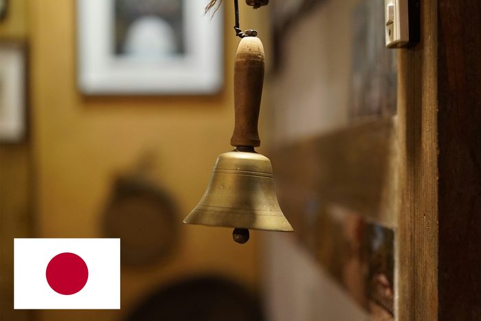 bell hanging near door with japan flag