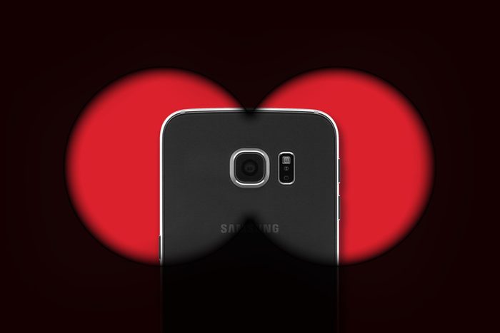 Android phone behind the dark view of binoculars, to represent malware or spyware
