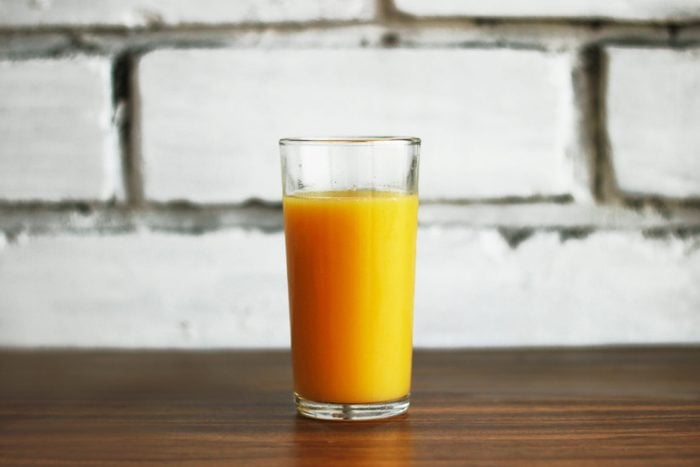 fresh orange juice in a glass on a brick wall background in a loft style