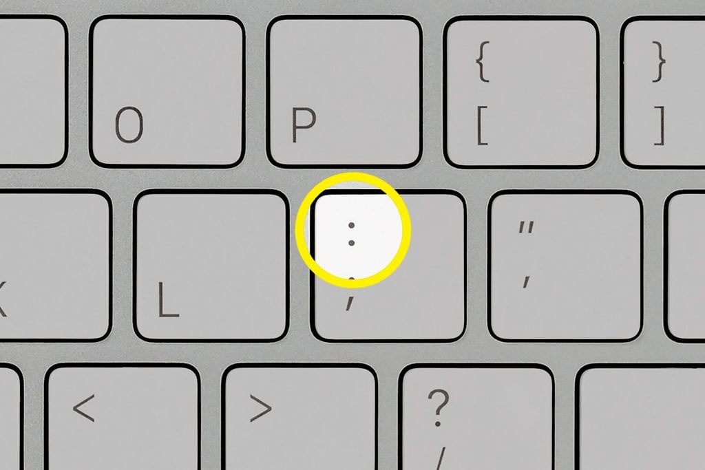 close up of a computer keyboard with the a highlight on the colon punctuation key
