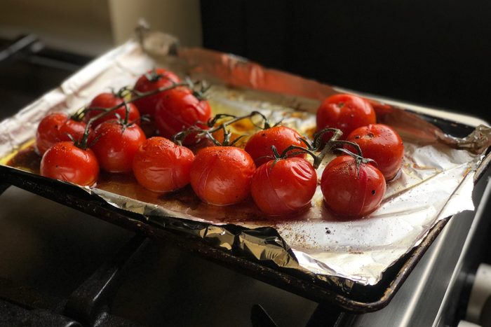 high angle view of roasted tomatoes on a pan lined with aluminum foil