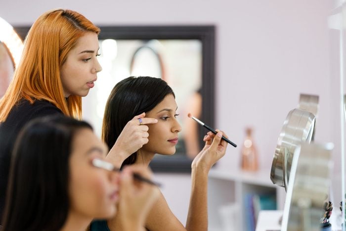 Make-up artist teaching young women about make-up