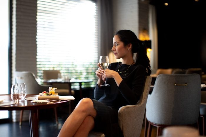Young woman staying in boutique hotel enjoying aperitif