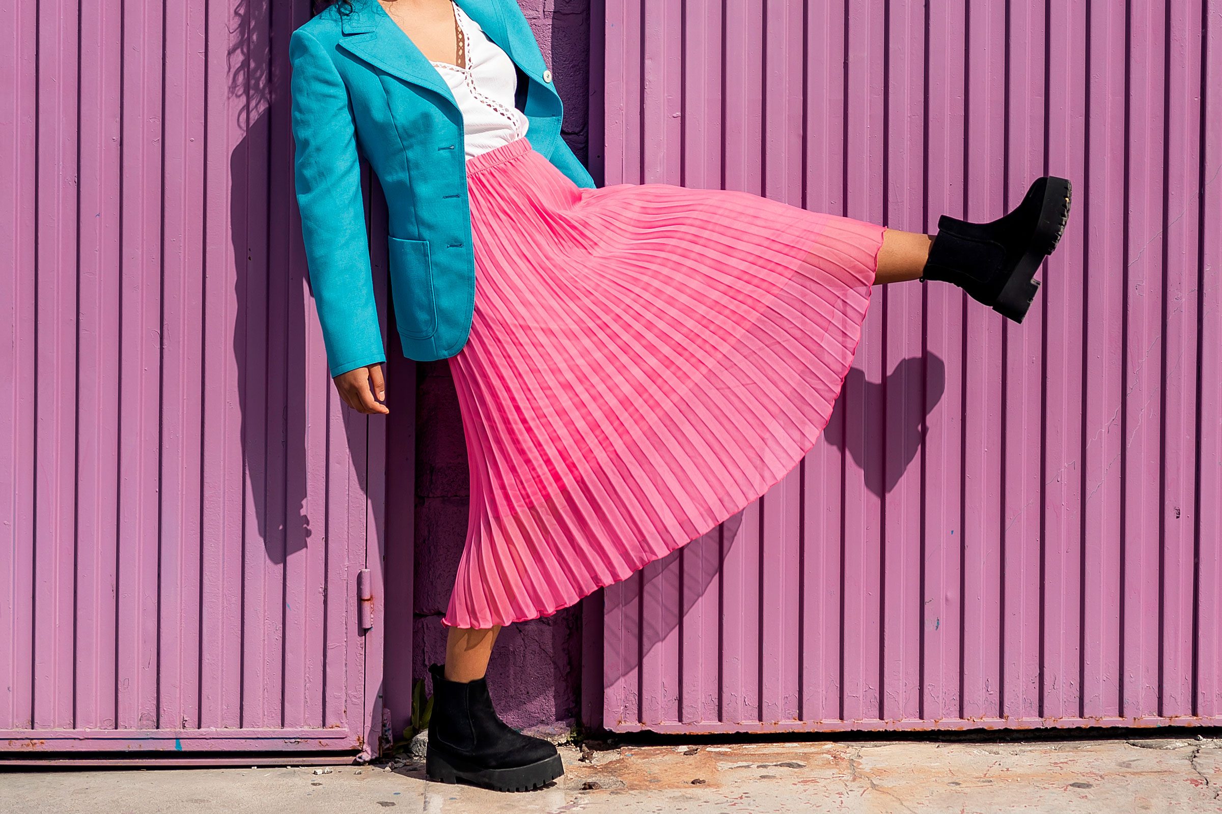 woman wearing a bright pink skirt and a blue blazer