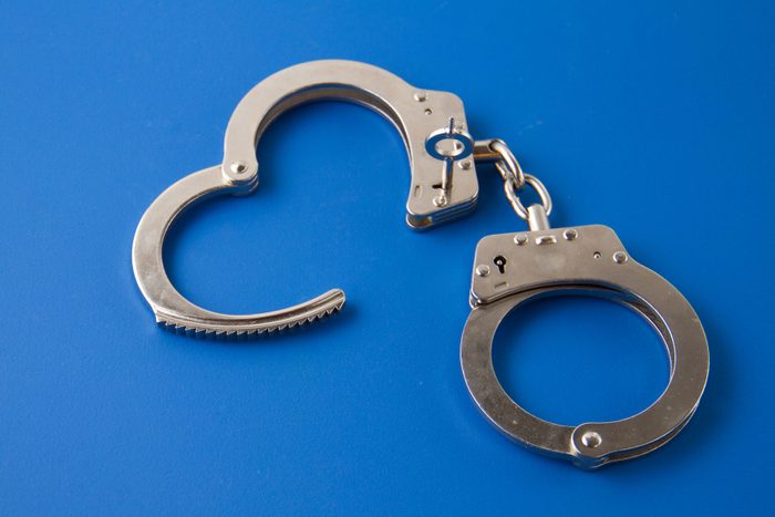 Open handcuffs on blue background