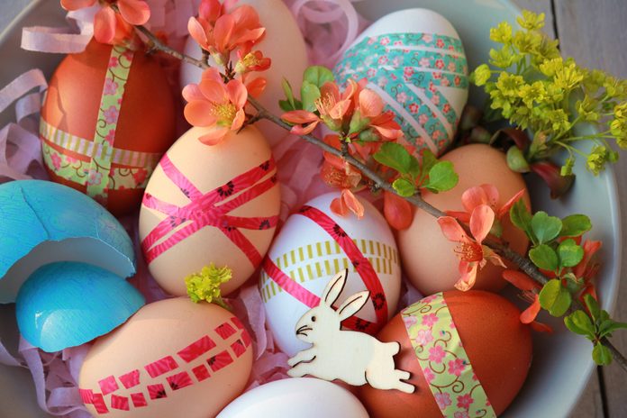 Easter eggs decorated with washi tape on wooden background