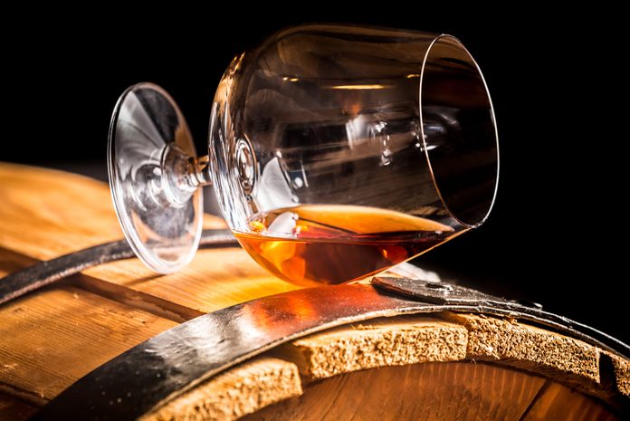 Glass of brandy on an old wooden barrel
