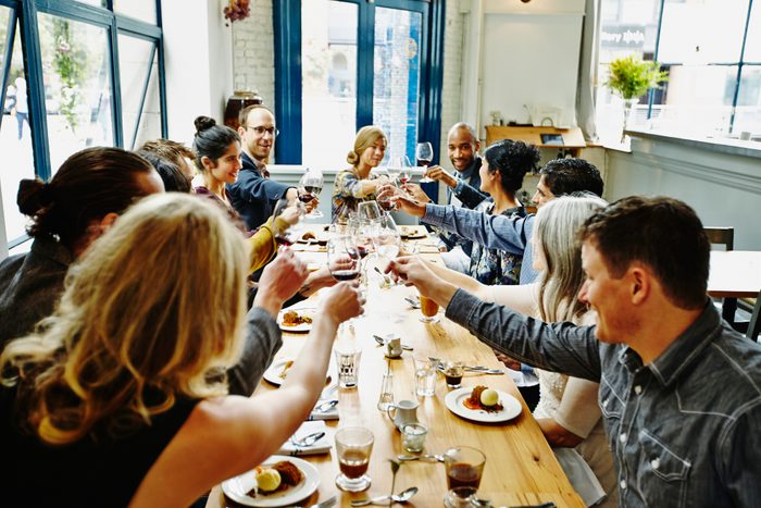 Smiling group of friends toasting at dinner party