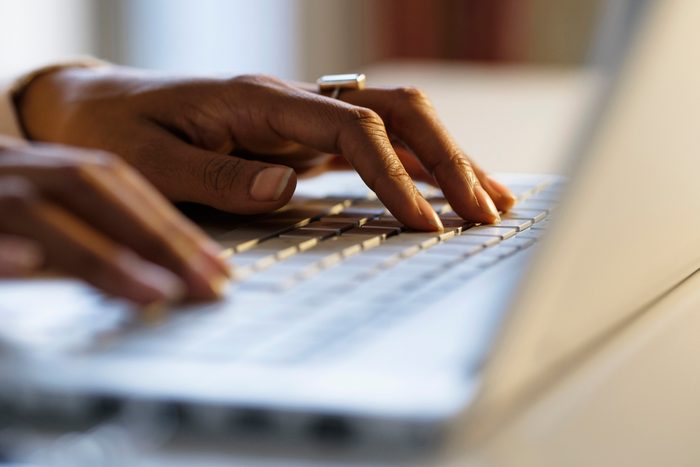Mixed race woman using laptop at desk