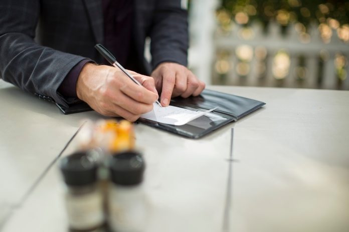 Businessman signing the bill at restaurant