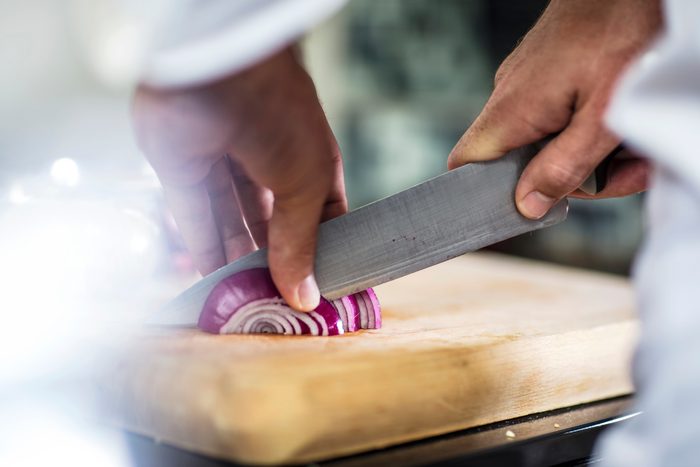 Chef slicing red onion, close-up