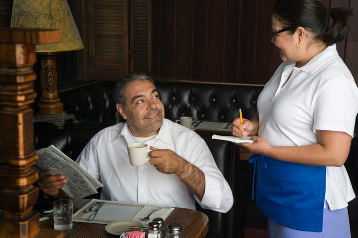 Hispanic man ordering food at diner
