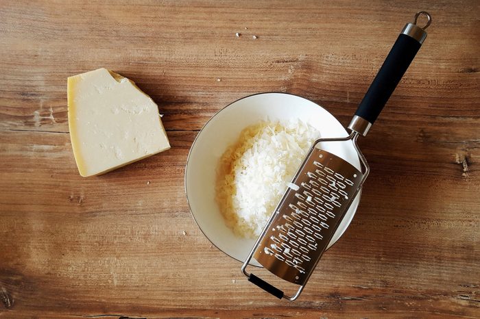 High Angle View Of Cheese With Grater On Wooden Table