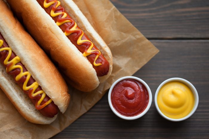 Barbecue Grilled Hot Dog with Yellow Mustard on wooden table