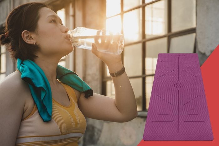 young woman drinking water after workout