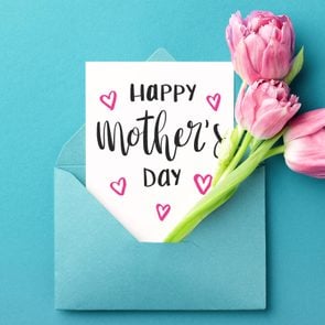 paper and pink flowers sticking out a blue envelope on blue background. card reads 