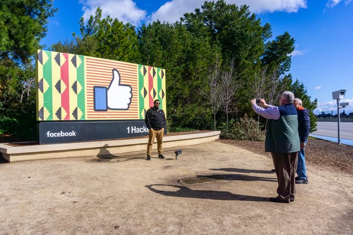 Group of people taking photos with the Facebook sign customized for black history month