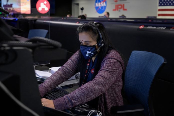 Perseverance Mars rover mission commentator and guidance, navigation, and controls operations Lead Swati Mohan studies data on monitors in mission control, February 18, 2021 at NASA's Jet Propulsion Laboratory in Pasadena, California.