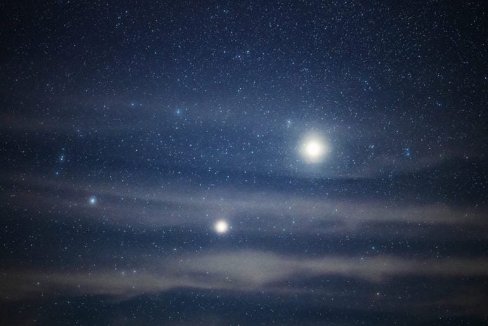Bright jupiter and saturn shining above clouds