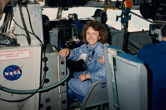 American NASA astronaut Christa McAuliffe smiles, seated near the controls of a Boeing KC-135 Stratotanker flying for the Johnson Space Center from Ellington Field Joint Reserve Base in Houston, Texas, 16th October 1985.