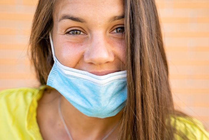 Smiling Young Woman Wearing Protective Face Mask Below Her Nose